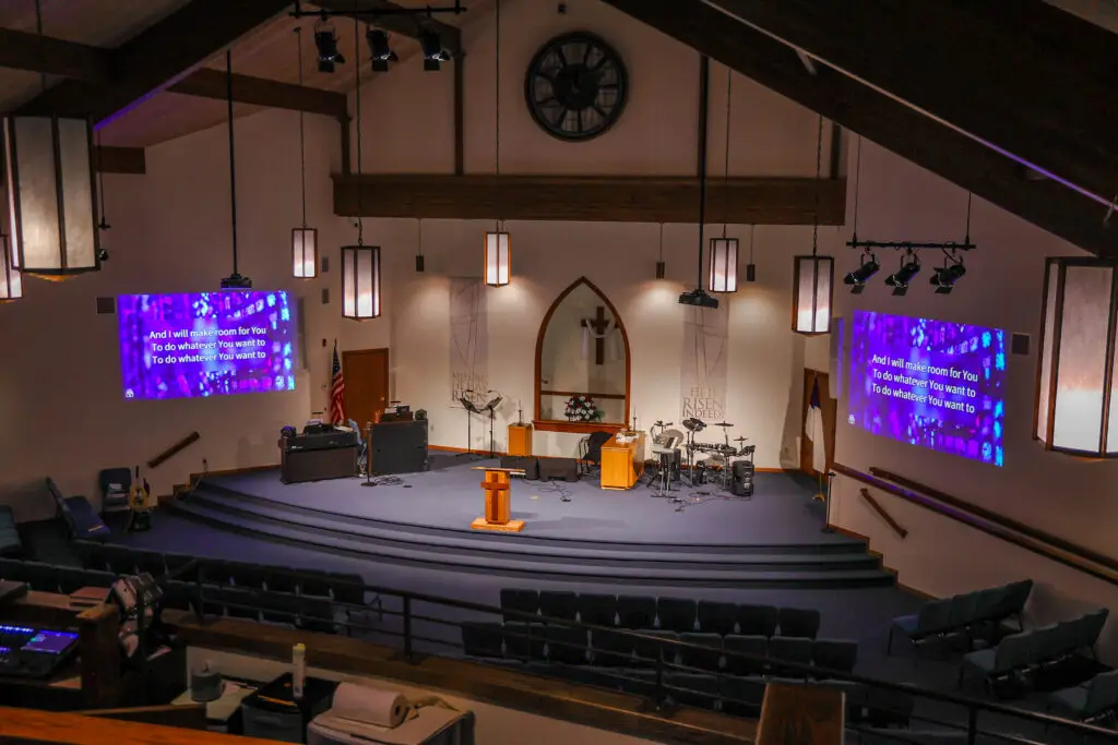 Church sanctuary ceiling with mounted projectors and new stage lighting fixtures
