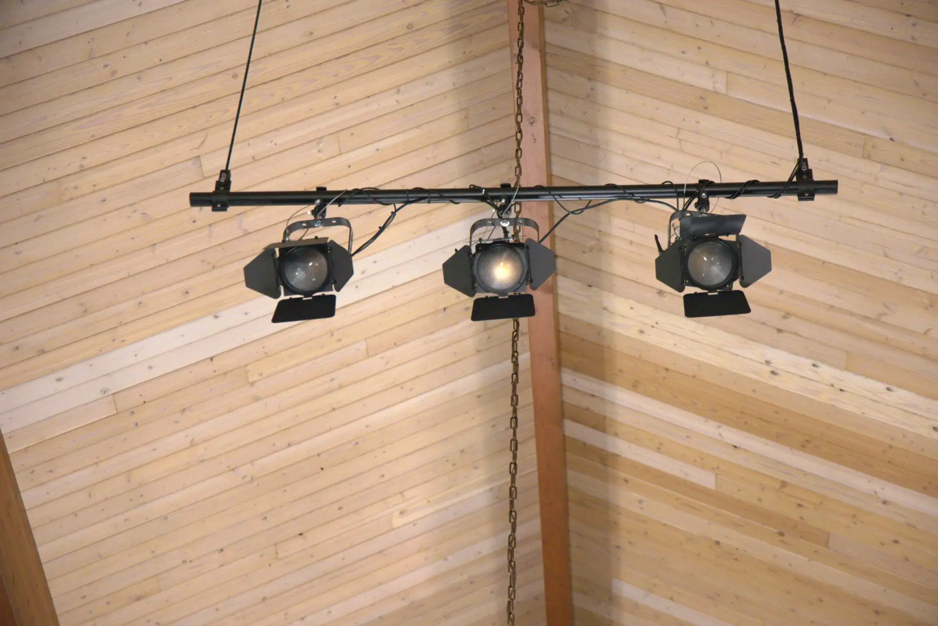 Three Chauvet stage lighting fixtures mounted on a suspended lighting bar