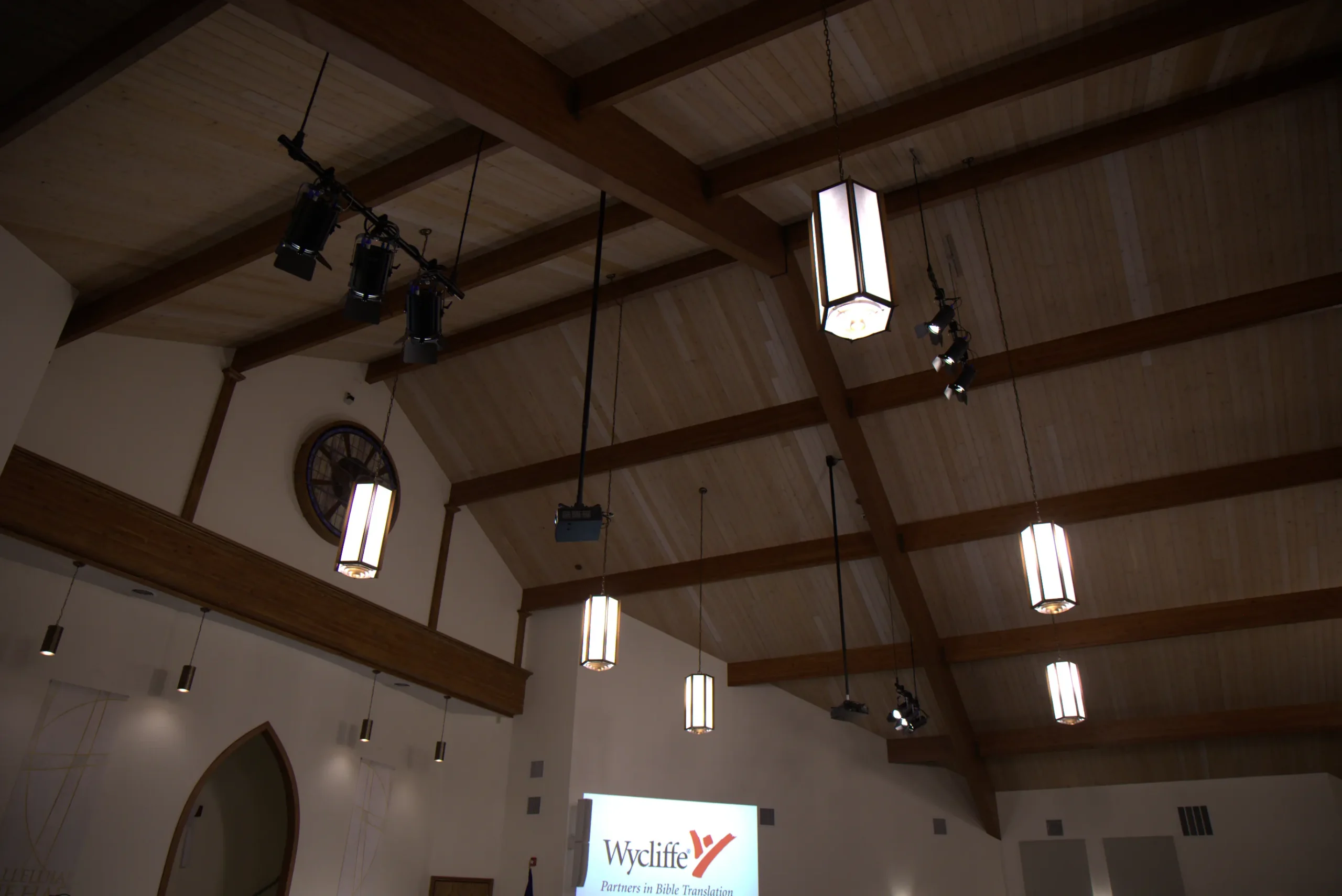 Church sanctuary showing upgraded stage lighting and bright Panasonic projection screens