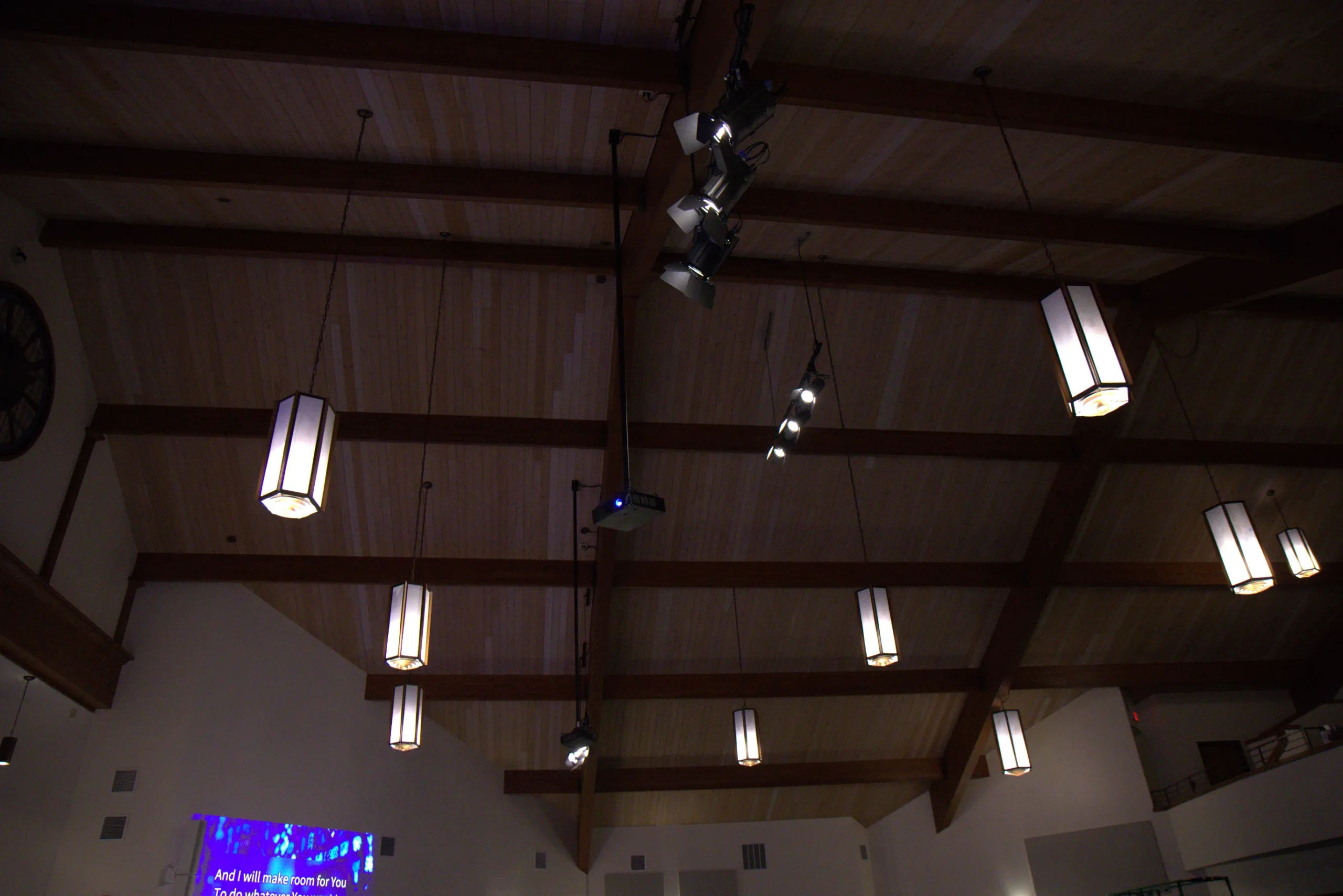 Ceiling-mounted church stage lighting and projector installation in a traditional worship sanctuary