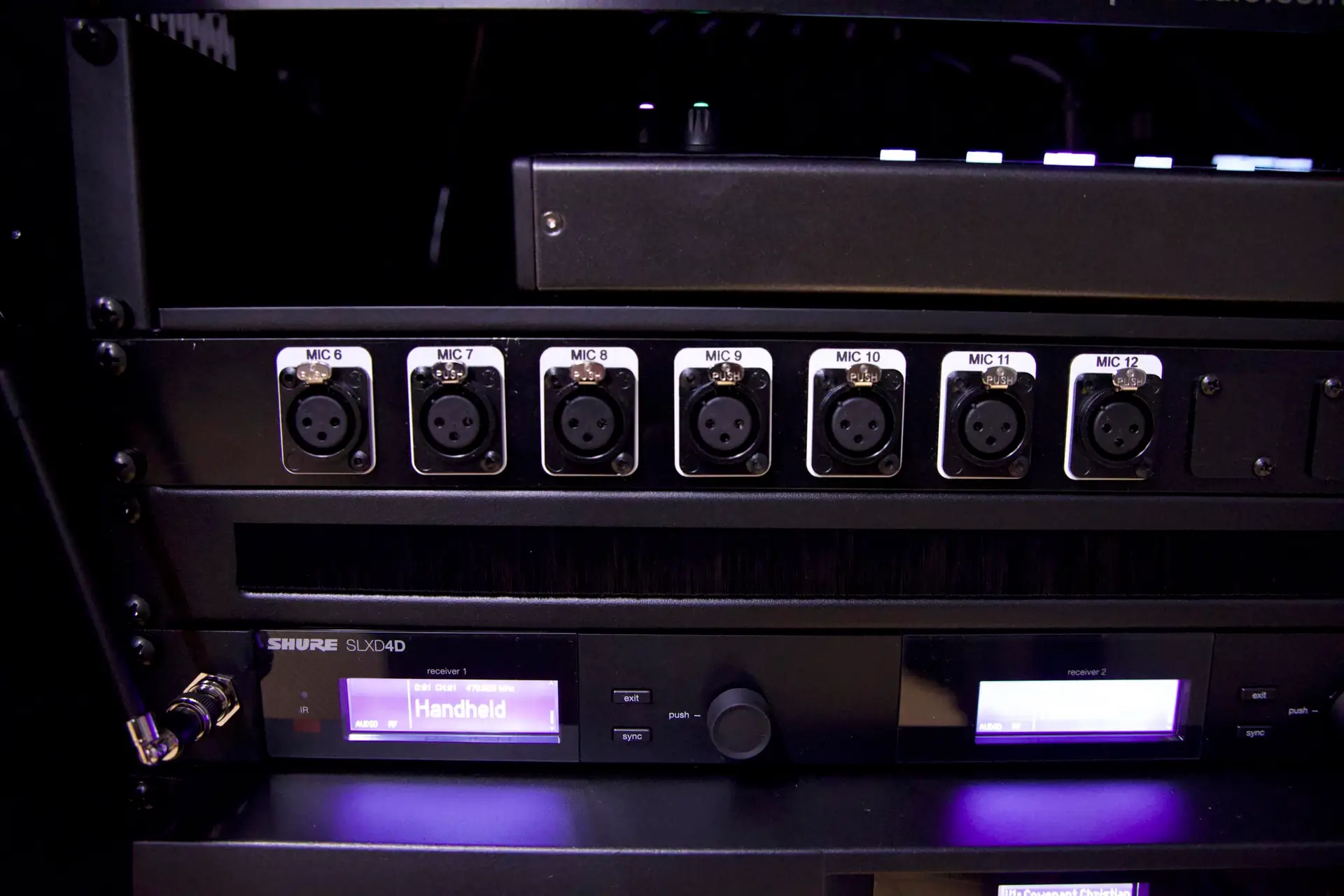 Audio patch panel and Shure SLX-D wireless microphone system installed in custom AV rack